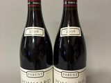 two bottles of red wine sitting on top of a table