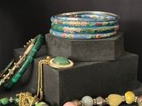 a stack of bracelets and necklaces sitting on a table