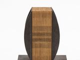 sculpture représentant un bloc de bois sur un socle noir, sur fond blanc