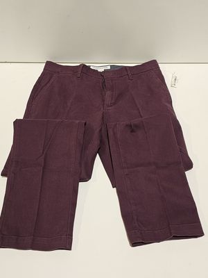 un gros plan sur un pantalon violet posé sur une surface blanche