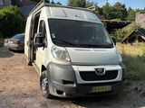 une camionnette blanche garée sur le bord d'un chemin de terre