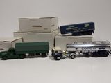 Plusieurs camions miniatures sont alignés les uns à côté des autres sur une surface blanche