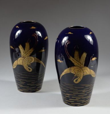 une paire de vases bleus ornés de motifs dorés sur fond blanc