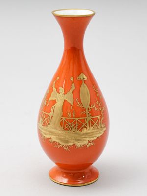 un vase orange orné d'un motif doré
