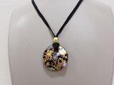 necklace with a black and gold pendant with a flower design on a black cord