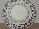 blue and white plate with a design on the outside of it