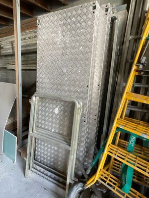 de nombreux morceaux de métal dans une pièce où se trouve une échelle