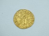 a close up of a gold coin on a white surface