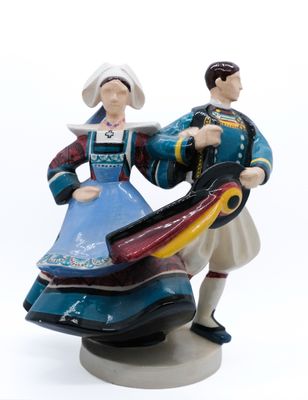 une figurine représentant un homme et une femme tenant un cerf-volant