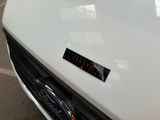 a close up of a white car with a sticker on it