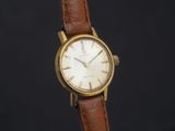 une photo d'une montre-bracelet plaquée or avec un bracelet en cuir marron