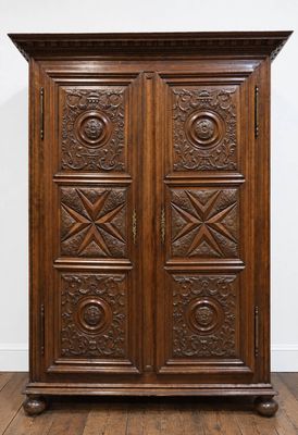 an antique wooden armoire with carved panels and drawers