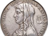 une vieille médaille en argent sur laquelle est représenté le visage d'une femme