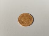 a close up of a gold coin on a white surface