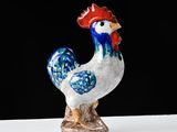 a figurine of a rooster on a white surface