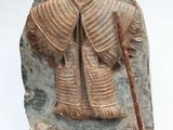 statue of a man holding a staff on a stone block