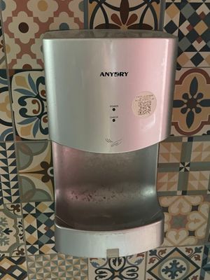 un distributeur d'eau fixé sur un mur carrelé dans une salle de bains
