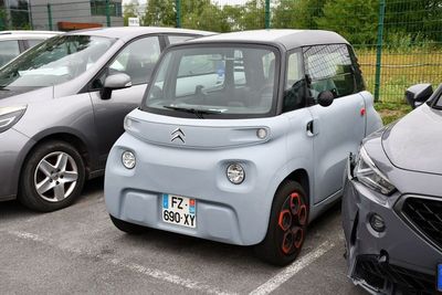 deux petites voitures garées l'une à côté de l'autre sur un parking