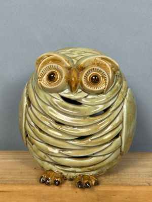 un hibou en céramique posé sur une table en bois