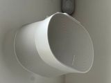une enceinte blanche accrochée au mur à côté d'une porte