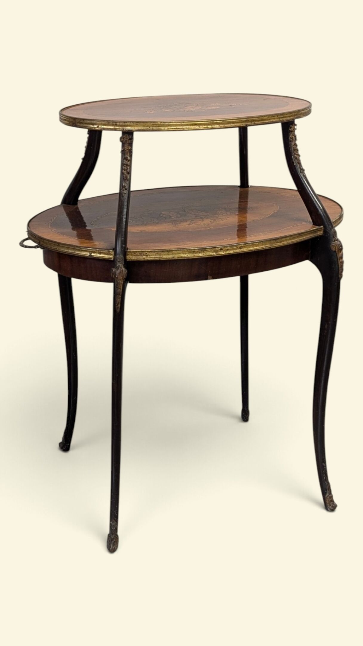 Table à thé à deux plateaux superposés de section ovale.