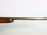 an old rifle with a wooden handle on a white background