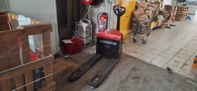 un chariot élévateur à fourche garé devant un bâtiment