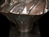 statue of a woman with a hat on a black background