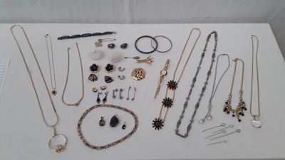 many different necklaces and bracelets displayed on a table