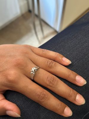 la main d'une femme, ornée d'une bague en diamant, posée sur un canapé