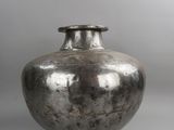 an old silver vase sitting on top of a white table