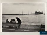 black and white photograph of a group of people sitting on a bench