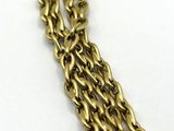 a close up of a gold chain bracelet on a white surface