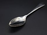 a close up of a silver spoon on a black surface