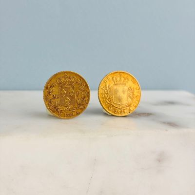 deux pièces d'or posées sur un plan de travail en marbre