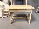 a small table with a drawer on it next to a chair
