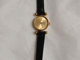 l'image d'une montre noire et or sur une surface blanche
