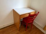a small desk and chair in the corner of a room