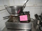 a frying pan on a stove with a pink sign on it