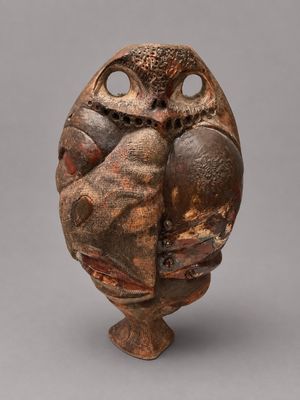 un vase marron orné d'un hibou sur le dessus