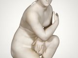 an image of a statue of a woman kneeling on a marble block
