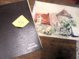 une photo d'une photo représentant une maison et un bout de papier posé sur un bureau