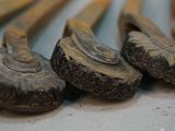 five wooden spoons sitting next to each other on a table