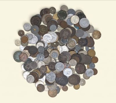 a pile of old coins on a white surface