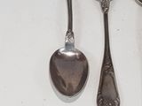 two spoons and a spoon rest on a table
