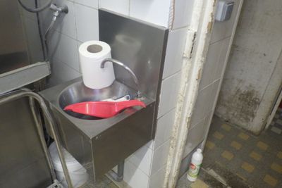 a toilet paper dispenser with a red spatula in it