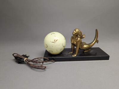une statue représentant une sirène et une boule posée sur un socle