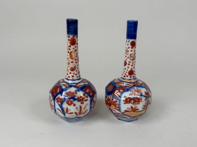 une paire de vases bleus et blancs ornés de fleurs, posés sur un fond blanc
