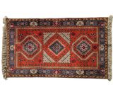 an orange and blue rug with a diamond design on it