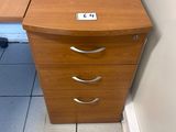 a desk with a file cabinet in the corner of the room